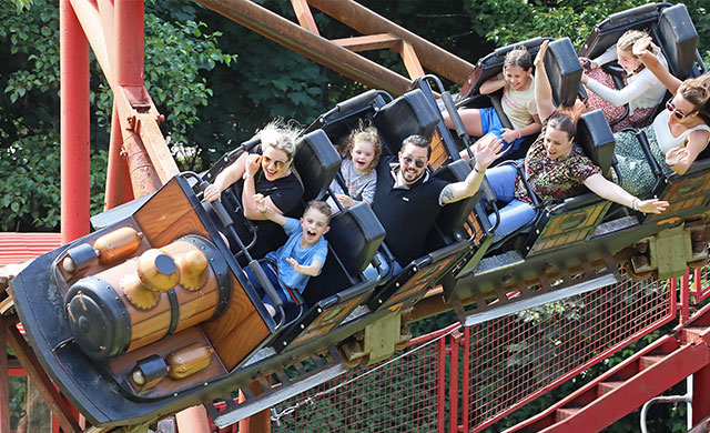 People on a theme park rollercoaster train