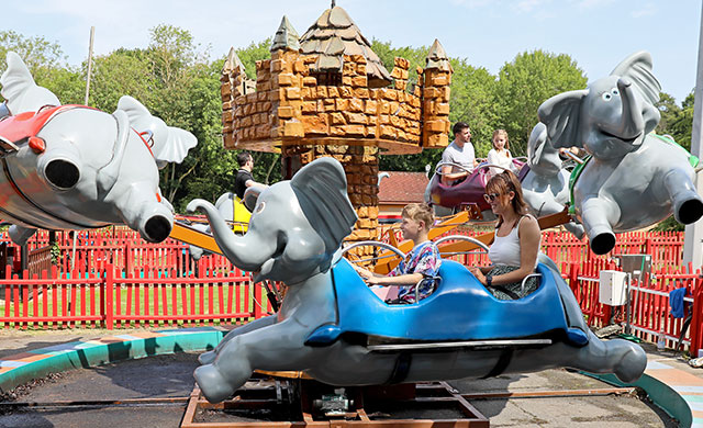 Families on flying elephant amusement ride