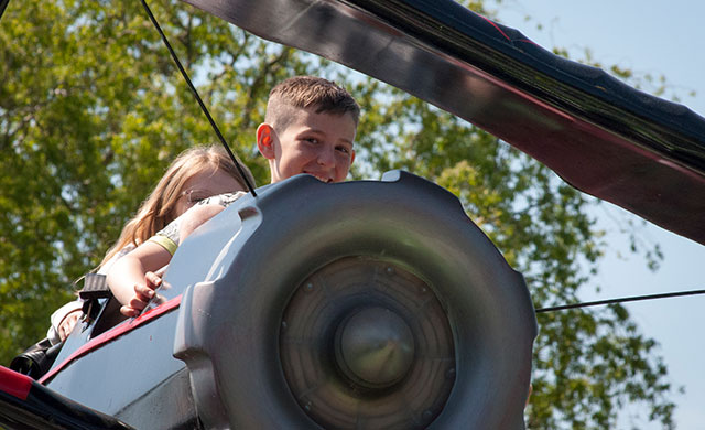 Young boy and young girl on aeroplane theme park ride