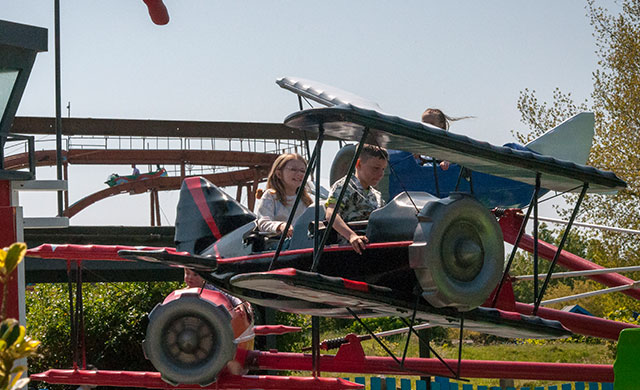 Children on aeroplane theme park ride