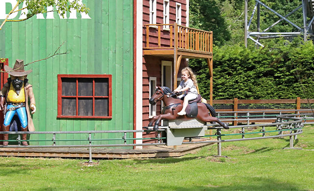 Young girl on horse amusement park ride