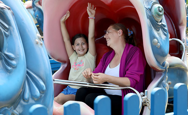 Woman and young girl on whale theme park ride