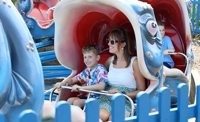 Woman and young boy on whale theme park ride