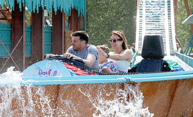 Man, woman and children on a log flume ride
