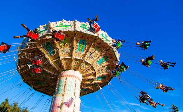 People on a waveswinger ride at a theme park
