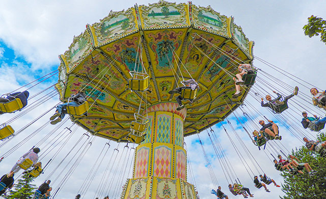 People on a waveswinger ride at a theme park