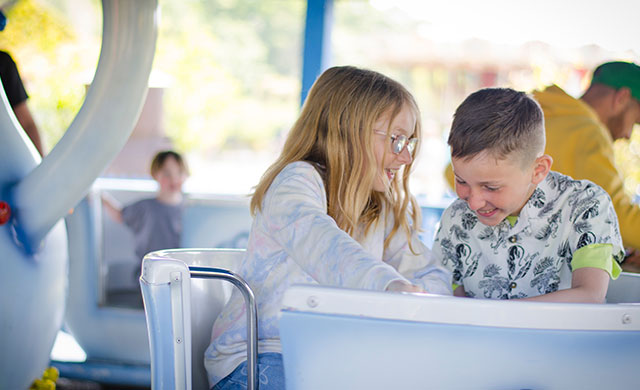 Young boy and young girl on teacup amusement ride